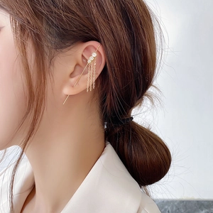 Detail of gold ear crawler earring with three clear zircons and delicate hanging chains