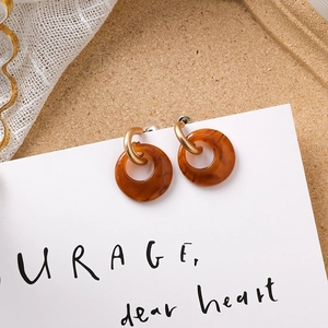Vue détaillée des boucles d'oreilles en résine ambrée avec texture marbrée et détails dorés