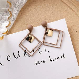 Vue détaillée de boucles d'oreilles carrées géométriques marron mat avec accents dorés