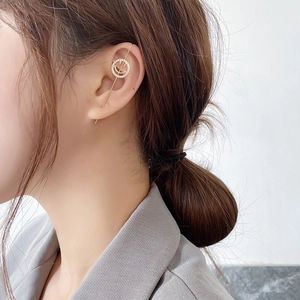 Close-up of a gold smile ear cuff with sparkling zircons worn by a female model