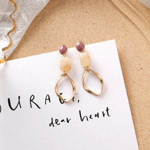 Détail de boucles d'oreilles vintage avec gemmes violettes et anneaux dorés tordus