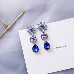 Detail of blue and purple gemstone drop earrings with marquise and teardrop cut stones