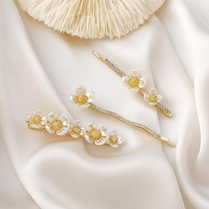 Ensemble de barrettes à fleurs en nacre et strass sur un fond de satin élégant