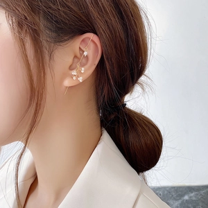 Elegant gold ear crawler with white pearls in a minimalist nature-inspired branch design