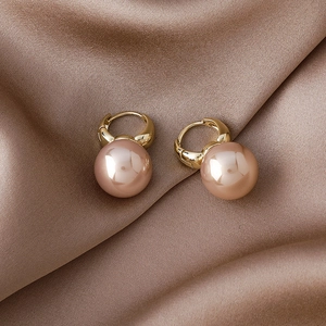 Elegant gold hoop earrings with rose gold mirror spheres on brown silk fabric