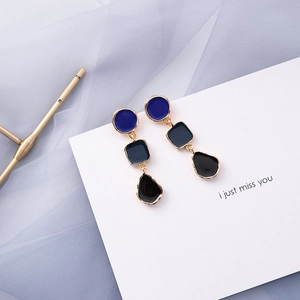 Detail of geometric blue and black drop earrings with gold-plated metal accents