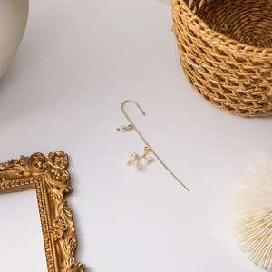 Detail of elegant gold long hook earring featuring white pearl clusters in a vintage setting