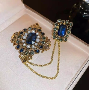 Broche vintage avec chaînes dorées, perles et pierres bleues style émeraude