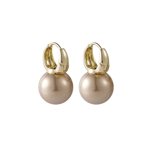 Detail of luxury gold huggie earrings with large champagne pearl drop pendants