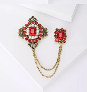 Détails de la broche baroque vintage avec double chaîne et pierres rouges taillées en émeraude