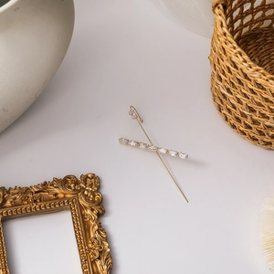 Detailed close-up of golden crawler earrings with rectangular zirconia on vintage background