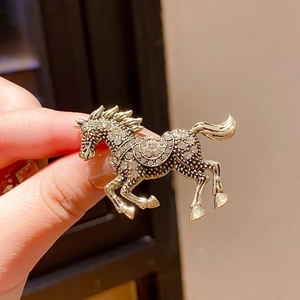 Macro detail of luxury vintage horse brooch with enamel and sparkling rhinestones