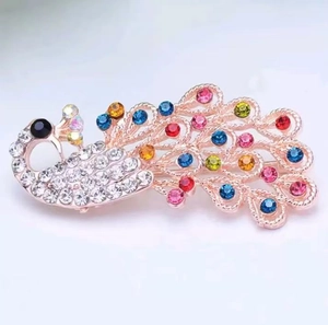 Detail of rose gold peacock brooch with colorful rhinestones and intricate crystal feathers