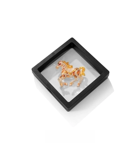Detailaufnahme einer goldenen Pferde-Brosche mit Strasssteinen in einer schwarzen Display-Box