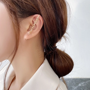 Detail of gold crystal ear cuff showing interlocking chain links and sparkling zircons