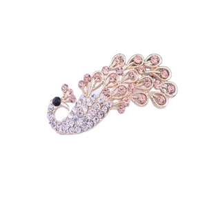 Detail shot of peacock brooch with gold plating and sparkling pink and white rhinestones
