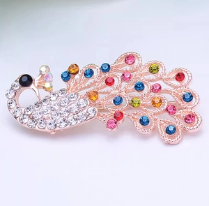 Macro detail of Chinese style peacock brooch with colorful rhinestones in rose gold finish