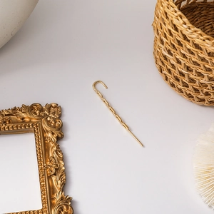 Detailed view of elegant gold-toned geometric ear cuff with shimmering micro-pave crystals