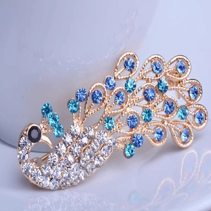 Exquisite peacock brooch with blue crystal rhinestones on a gold plated metal base