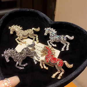 Macro shot of four vintage enamel horse brooches with sparkling rhinestones in a gift box