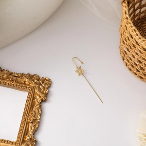 Detail of elegant gold snowflake ear cuff with shimmering crystals on a white background