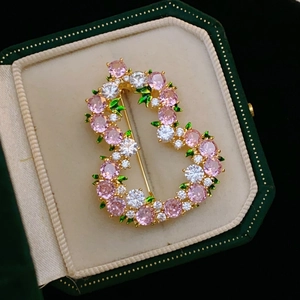 Dettaglio spilla da giardino con cristalli rosa e foglie di smalto verde su base d'oro