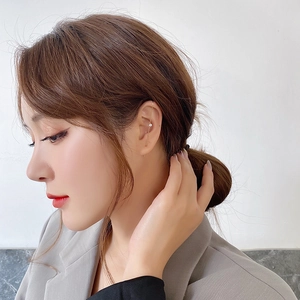 Detail of a gold minimalist ear cuff with small sparkling zircon worn by a professional model