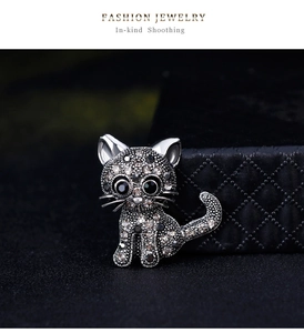 Macro shot of silver-tone alloy cat brooch with sparkling grey and white rhinestones