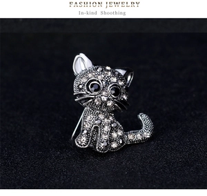 Detailed macro of vintage alloy cat brooch with sparkling rhinestones on dark background