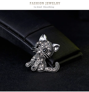 Detailed view of sitting cat brooch with sparkling white and grey rhinestones on jewelry box
