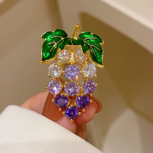 Détail d'une broche raisin avec zircons violets et feuilles en émail vert élégantes