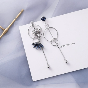 Detail of asymmetric blue crystal drop earrings with silver tassels and geometric design