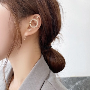 Close-up of golden ear crawler earring with marquise-cut zircons worn by a model