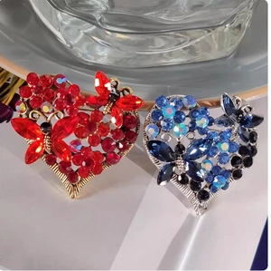 Vintage heart brooches with colorful rhinestones and butterfly details in red and blue