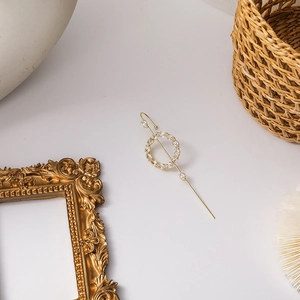 Detail of gold circular crystal earring with zircons and long needle on vintage decor
