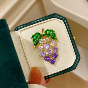 Broche raisin élégante avec zircons violets et émail vert dans un écrin de bijoux