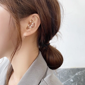 Detail of crystal zircon ear crawler earrings featuring three triangle stones in gold plating