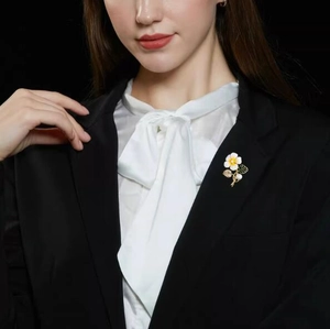 Broche fleur élégante avec perle blanche sur revers de veste noire pour femme