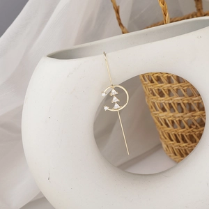 Minimalist gold Christmas tree earrings with sparkling cubic zirconia on ceramic vase