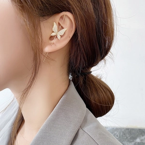 Elegant gold butterfly crawler earrings with crystal zircons on a female model