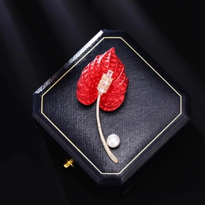 Luxurious red calla lily brooch with sparkling crystals and a white pearl on jewelry box