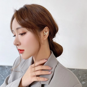 Close-up of a gold butterfly ear cuff with sparkling crystals on a female model