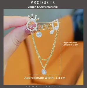 Detailed view of golden Queen brooch with crown and crystal chains measuring 6.7cm by 3.4cm