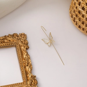 Detail of a gold butterfly ear cuff with sparkling white zircon crystals inlay