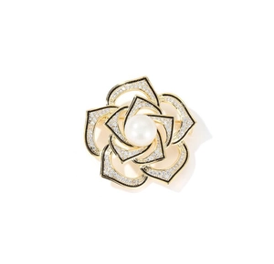 Detailed macro shot of vintage camellia brooch with gold plating and white zircon crystals