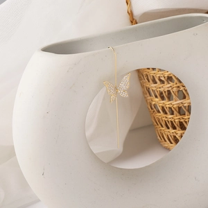 Detailed view of elegant gold butterfly ear threader earrings with sparkling zircons