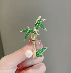 Detailed macro shot of green bamboo brooch with sparkling crystals and a white pearl
