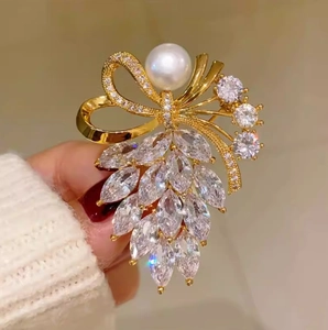 Broche ruban élégante avec zircons marquise et perle blanche sur finition dorée