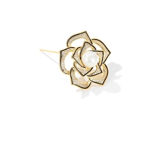 Close-up of vintage camellia brooch with gold base, white zircons, and a central pearl