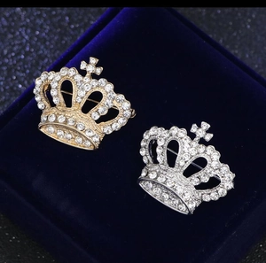Detailed close-up of golden and silver crown brooches with sparkling inlaid rhinestones